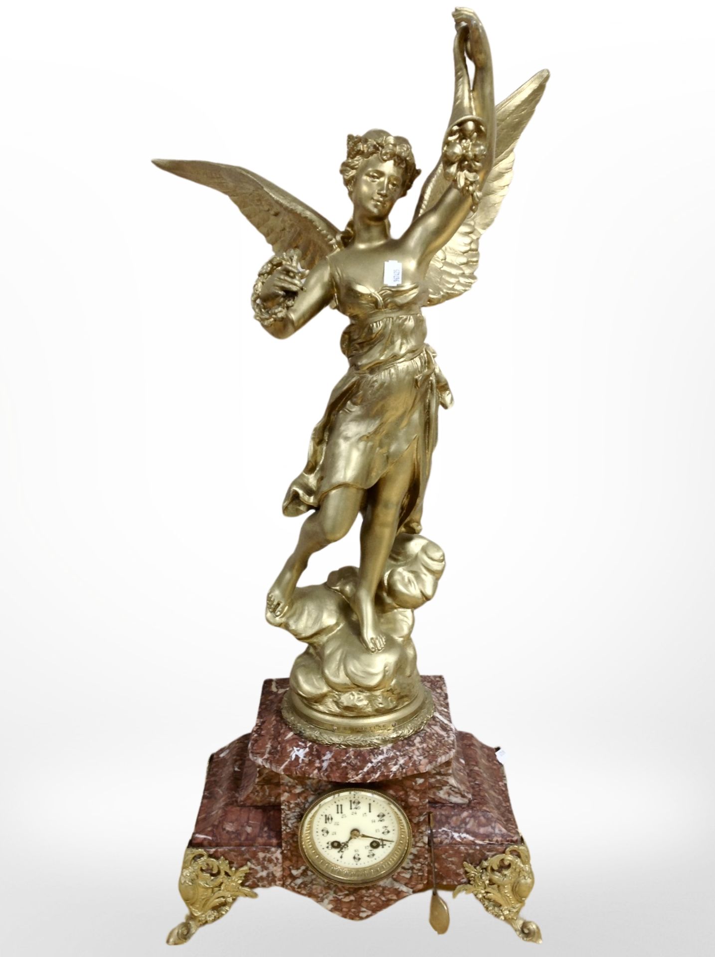 A French rouge marble and gilt metal eight day mantel clock surmounted by a figure of Fortune