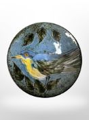 A 20th-century art pottery dish depicting a bird, diameter 14cm.