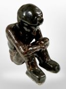 A treacle-glazed ceramic figure of a seated miner, height 12cm.
