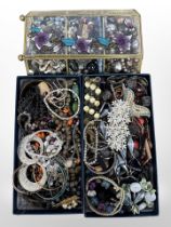 Two boxes and a display case of assorted costume jewellery, brooches, bracelets,