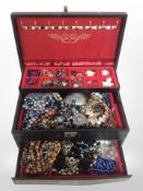 A multi-compartment jewellery cabinet containing a large quantity of costume jewellery,