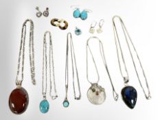 Five decorative silver pendants on chains, a further pendant and four pairs of silver earrings.