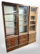 A pair of late Victorian glazed single door shop cabinets fitted with four drawers beneath,