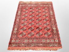 An Afghan design rug on red ground,