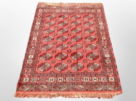 An Afghan design rug on red ground,