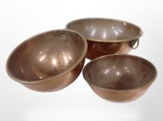 Three graduated copper bowls,