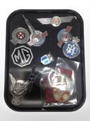 A group of vintage car badges and tax discs including MG, RAC, Morris, etc.