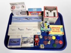 A tray containing enamel badges, Herpa miniature aircraft modelling kits, games, etc.