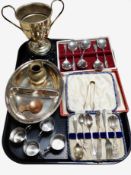 A collection of cutlery including pair of silver sugar tongs, silver-plated trophy cup on stand,