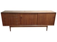 A Dalescraft teak low sideboard fitted sliding door cupboards and drawers,