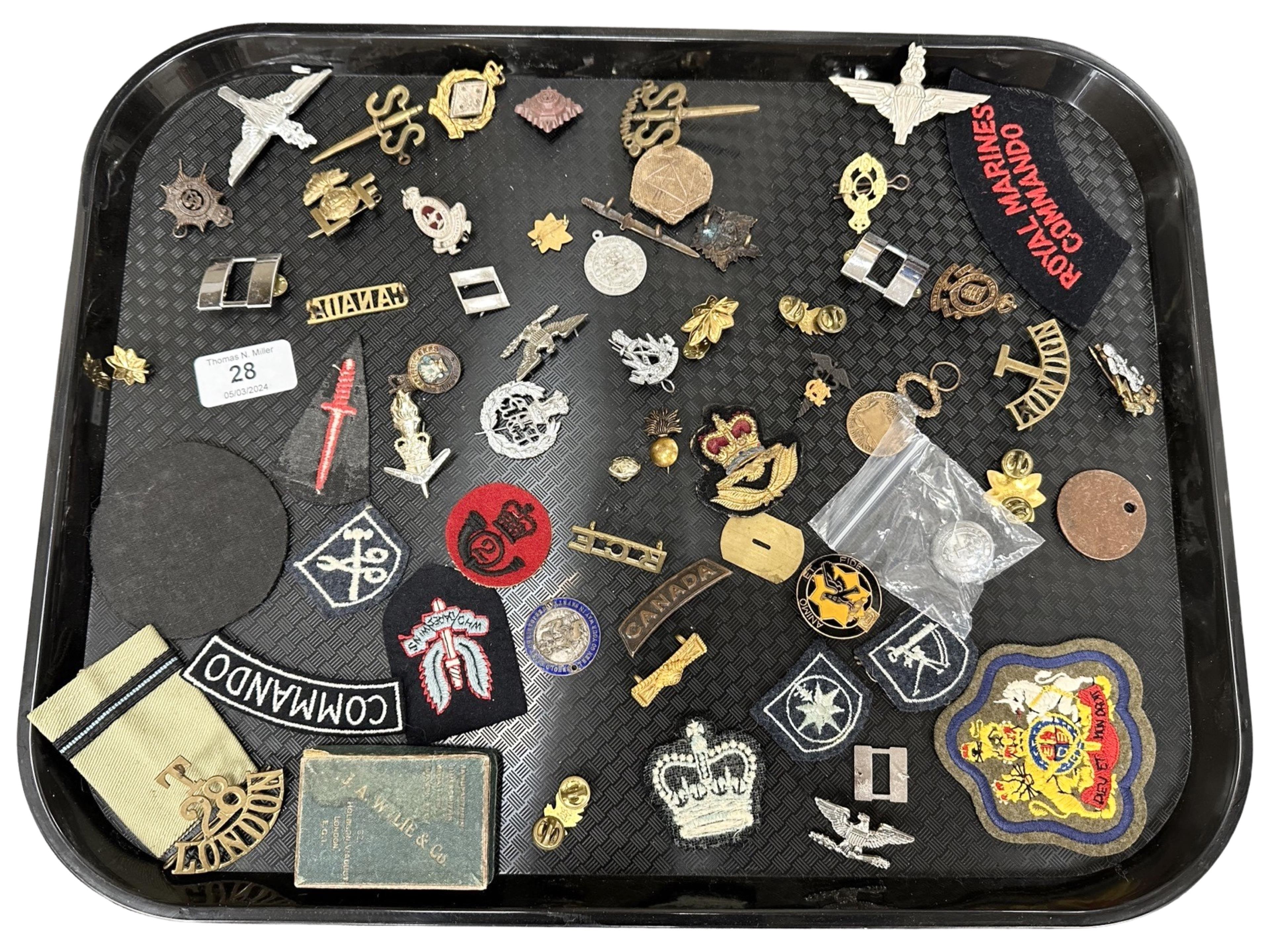 A group of military cloth and metal badges, etc.