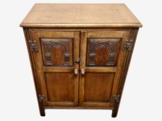 A reproduction carved oak low cabinet with plate glass top,