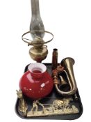 A brass oil lamp with red glass shade, together with a brass bugle, two coat racks,