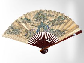A large oriental lacquered hand fan, width 130cm.