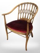 A beech open armchair with carved lattice back rest,