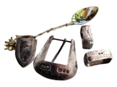An enameled continental silver teaspoon, together with other items including a belt buckle, etc.