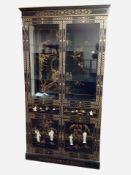 A Japanese style lacquered and inlaid glazed double door display cabinet,