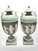 A pair of Wedgwood green Jasperware twin-handled lidded urns, height 22cm.