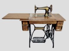 An antique Singer treadle sewing machine in oak table