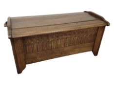 A reproduction carved oak linen fold blanket box,