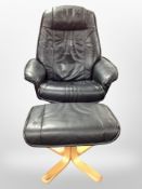 A contemporary black stitched leather swivel armchair on beech support with matching footstool