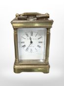 A miniature brass carriage timepiece signed Elliott and Son, London, height 10cm including handle.