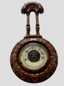 A heavily carved beech barometer, length 43cm.