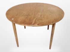 A 20th century teak extending circular dining table,