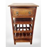 A contemporary stained pine table with wine rack and drawer beneath,