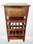 A contemporary stained pine table with wine rack and drawer beneath,
