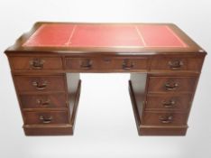 A reproduction mahogany twin pedestal writing desk with red tooled leather inset panel,