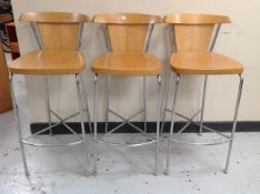 A set of three laminated beech high chairs on chrome metal supports