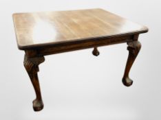 A Victorian oak wind out dining table, on large claw and ball feet,