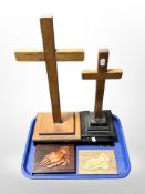 Two wooden crucifixes, two plaques depicting hands clasped in prayer, and a further metal stand.