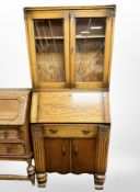 An Art Deco carved oak bureau bookcase with leaded glass panel doors,