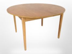A 20th century teak extending circular dining table,