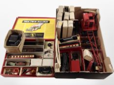 A box containing tin plate rolling stock, track, model crane, Trix model railway components, etc.