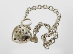 A silver heart pomander on silver bracelet set with an encrusted key.