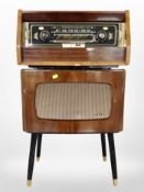 A vintage walnut-cased AGD Valve radio with a Dynatron speaker on tapered legs.