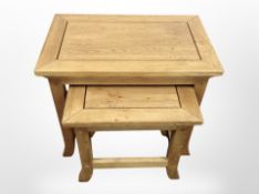 A contemporary oak nest of two tables,