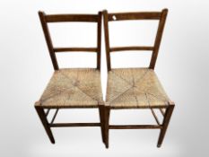 A pair of oak and rattan farmhouse dining chairs.