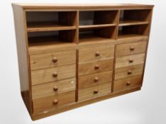 A contemporary bank of twelve drawers fitted shelves above,