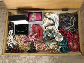 A wooden box of costume bead necklaces, ladies' wristwatch, beadwork purse, etc.