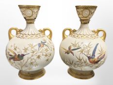 A pair of Royal Worcester gilt and hand-painted porcelain twin-handled vases decorated with