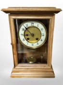 A beech-cased eight day mantel clock with enameled dial, height 30cm.