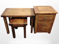A contemporary stained pine nest of tables and a further three drawer bedside chest