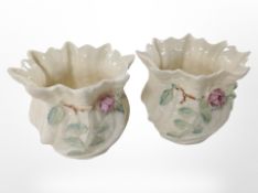A pair of Belleek porcelain pots decorated with flowers, height 9cm.