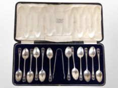 A cased set of twelve silver teaspoons and matching sugar tongs, retailed by David Summerfield,