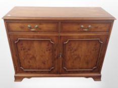 A reproduction yew wood sideboard,