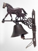 A cast-iron horse bell on bracket, length from wall 27cm.